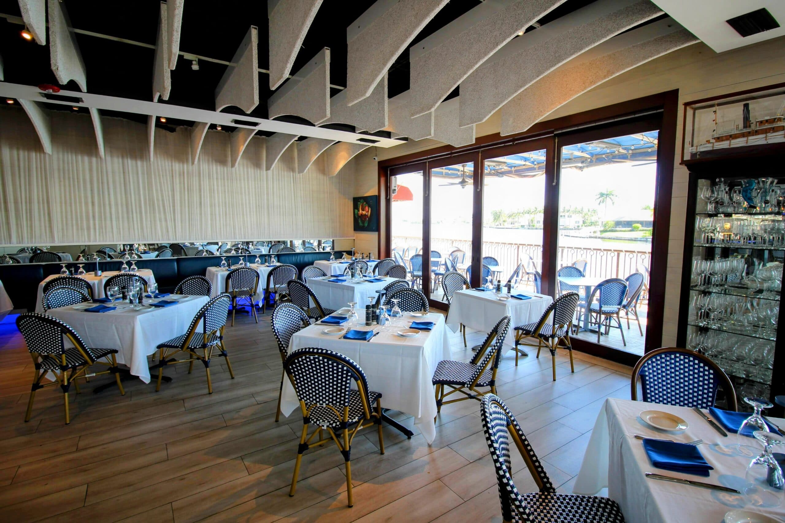 FISH dining room on Venetian Bay, white-lined tables beside open windows looking out to the water